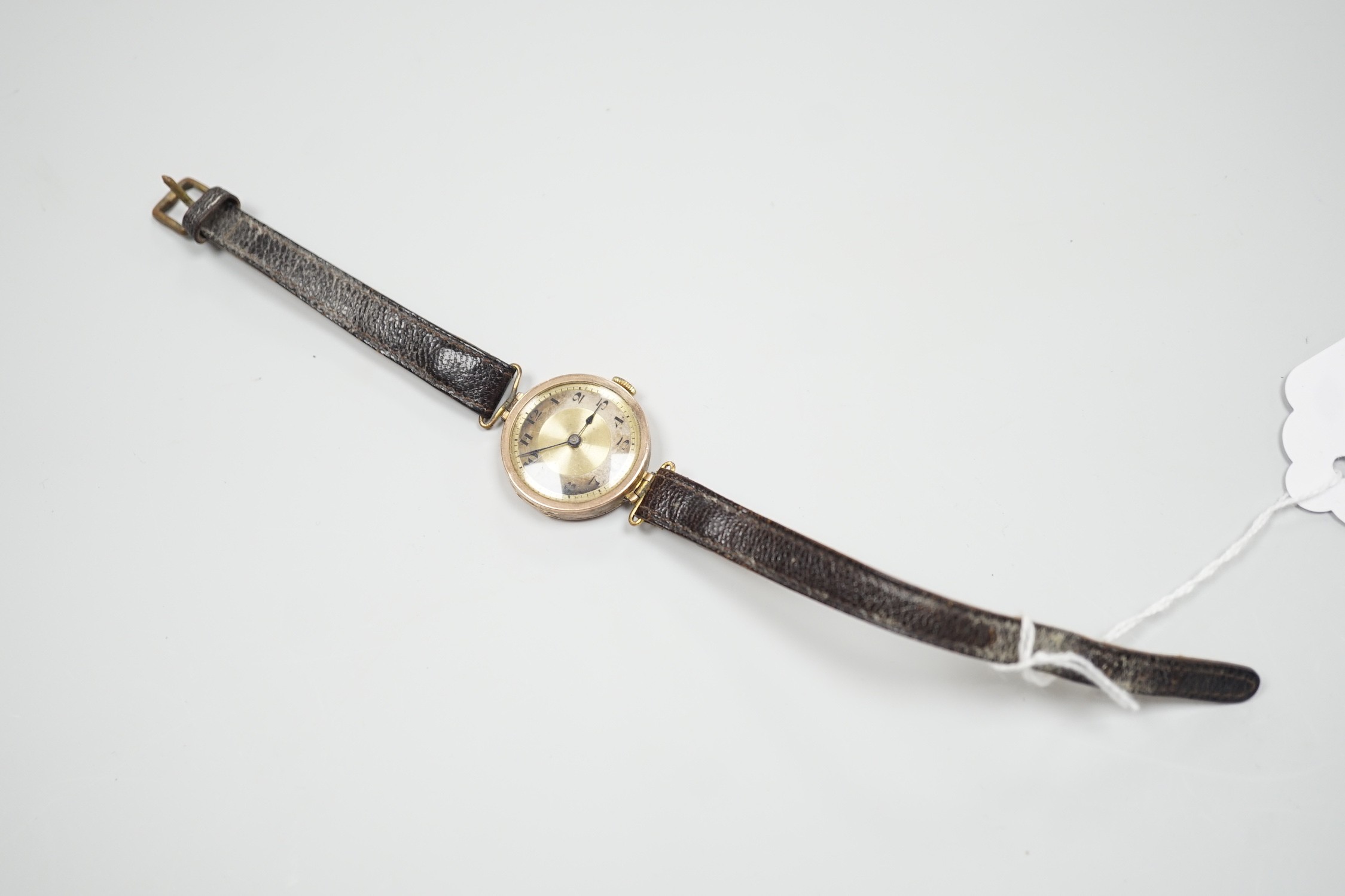 A lady's early 20th century 9ct gold wrist watch, with Arabic dial and RolWatchCo (Wilsdorf & Davis) case, movement unsigned, on associated leather strap, case diameter 26mm, gross weight 17.5 grams.